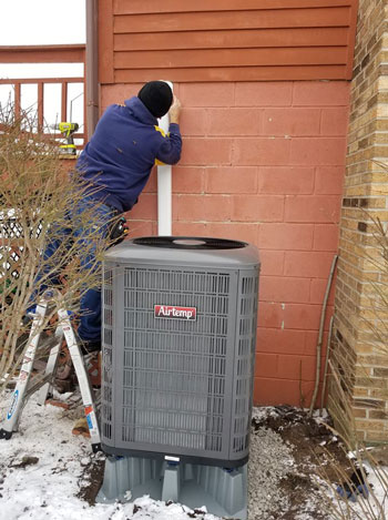 Northern Comfort Heating and Cooling technician repairing an air conditioning unit in in Rochester, NY
